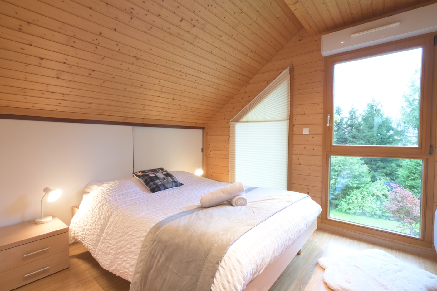Chambre en bois d'un chalet à Gérardmer, lit préparé et linge Linvosges